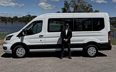 Tim Standing in front of Cal - a 14-seat vehicle